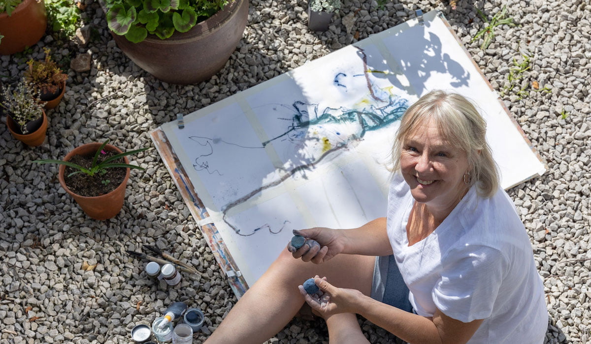 Caroline Rose Looking up at camera from her ground sketches