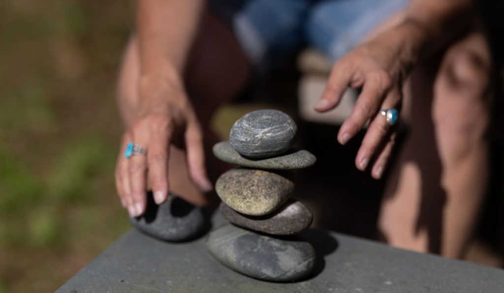 Caroline Rose stacking stones in meditation